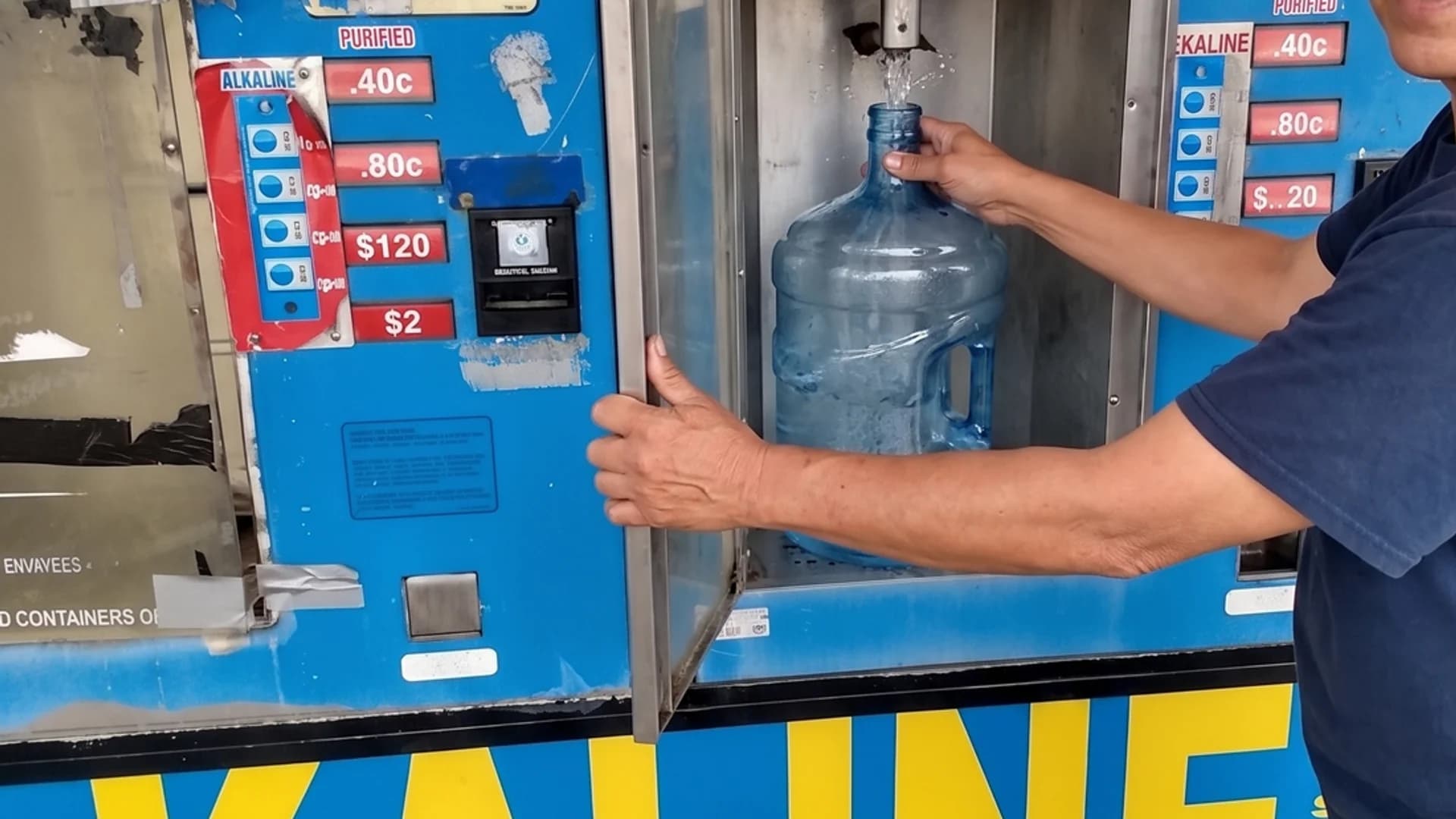 Customer filling a jug with alkaline water at Red Rock Springs Water refill station, 9132 W Sahara Ave Las Vegas