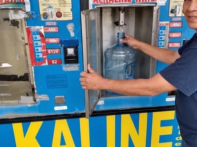 Customer refilling a 5-gallon water dispenser jug at the purified and alkaline water machine at Red Rock Springs Water, Las Vegas